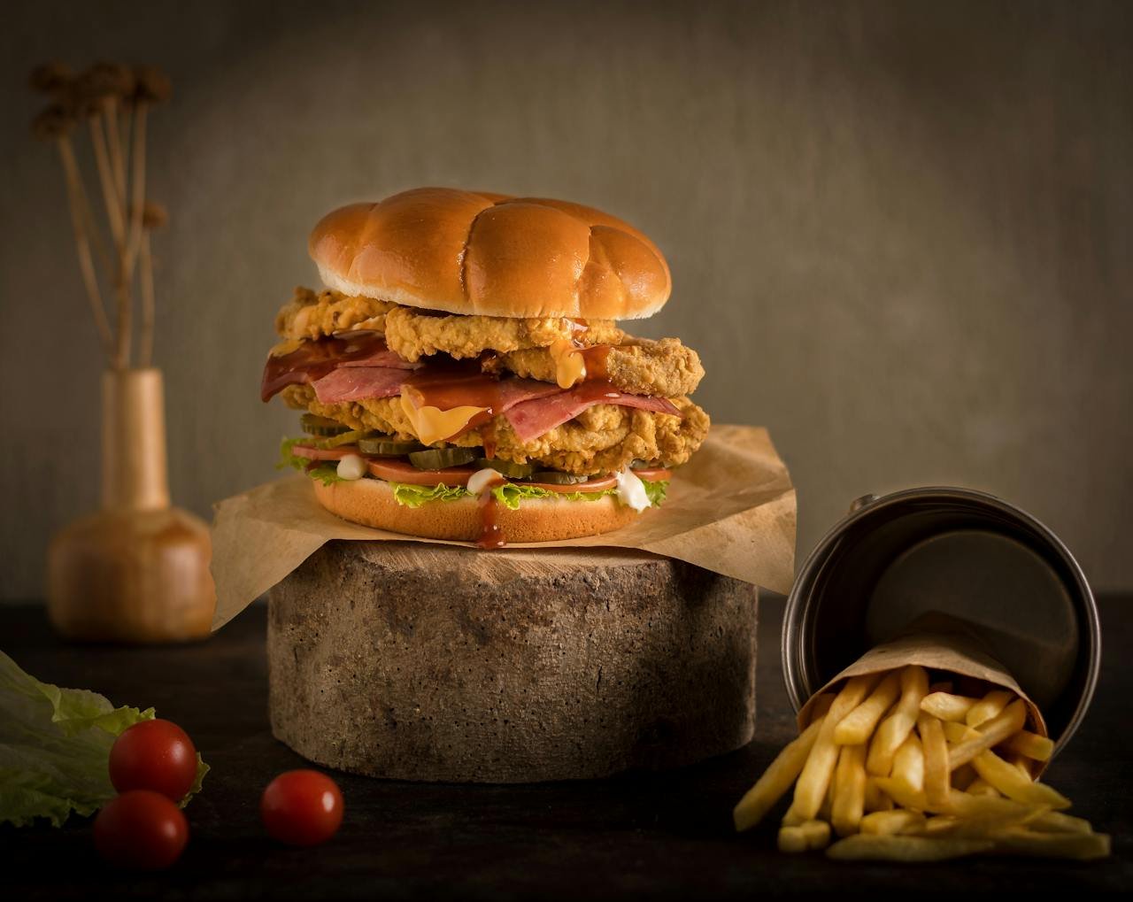 Close-up of a juicy gourmet hamburger with crispy fries on a rustic wooden surface.